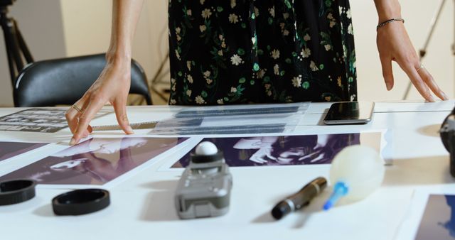 Hands Arranging Photographic Prints and Equipment on Table - Download Free Stock Images Pikwizard.com