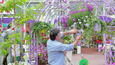 Man Enjoying Fragrant Flowers at Garden Center