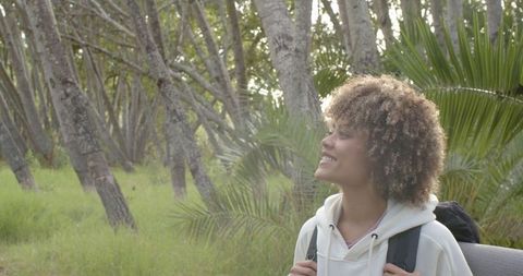 Smiling Young Woman Enjoying Nature Hike in Forest