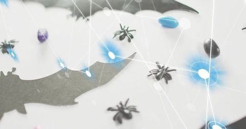 Spooky Halloween craft scene showing bat silhouette, toy spiders, candy and tech network overlay