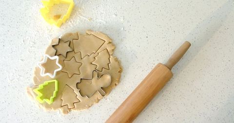 Cutting christmas cookie shapes from rolled dough with star tree gingerbread cutters