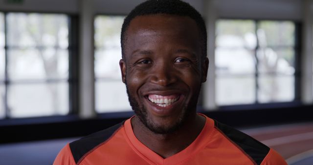 Smiling Athlete in Bright Orange Sportswear Indoors - Download Free Stock Images Pikwizard.com