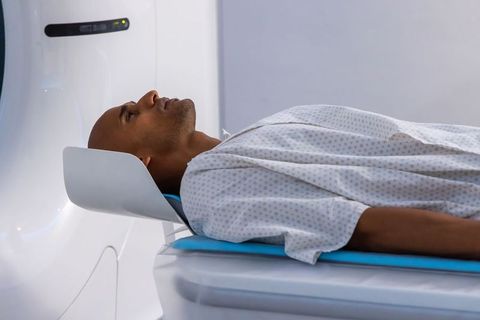 African man undergoing mri scan in hospital gantry wearing patient gown