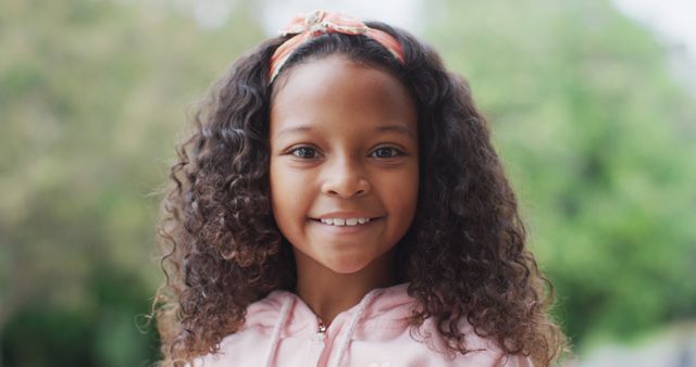 Image portrait of happy african american girl with long curly hair smiling to camera in garden - Download Free Stock Photos Pikwizard.com