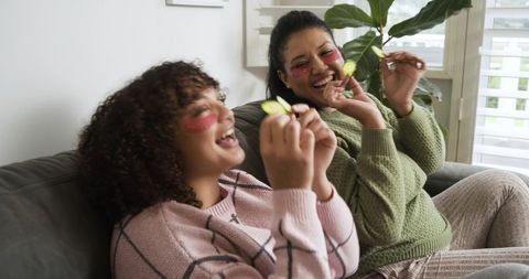 Diverse women enjoying at-home skincare routine with under-eye patches and cucumber slices
