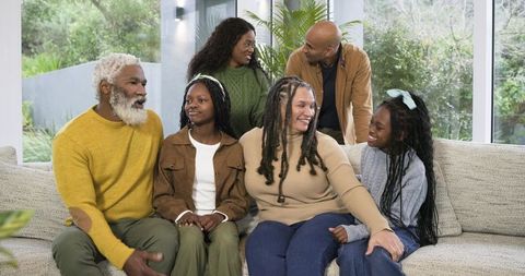 Intergenerational Multiracial Family Gathering Laughing Together on Cozy Living Room Sofa