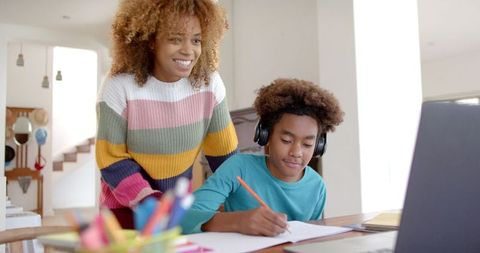 Mother Supporting Son with Online Homework Using Laptop