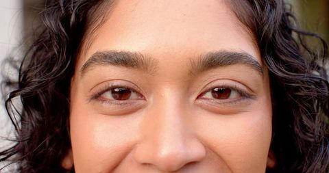 Serene Gaze of Smiling Woman in Lush Garden Setting