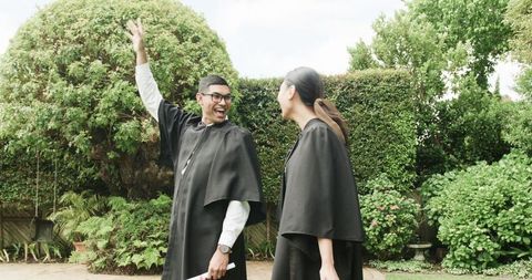 Joyful graduation celebration outdoors with academic achievers