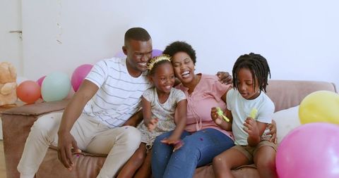 Joyful African American Family Playing with Bubbles and Balloons