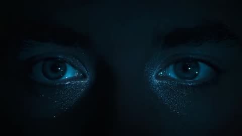 Eyes reacting to teal light, shifting left then returning center with glittered skin