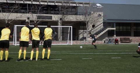 Soccer players taking penalty kick on school athletic field