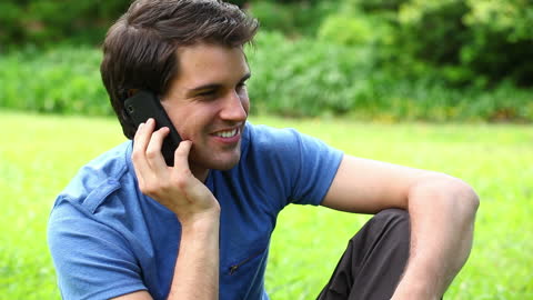 Man Smiling While Talking on Phone in Park