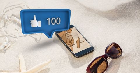 Social Media Concept with Phone and Beach Accessories on Sand