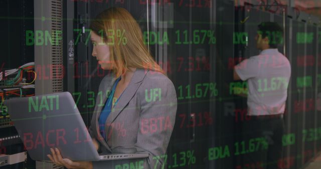 Image depicts female IT professional carrying a laptop while monitoring a data center. A digital overlay with stock market figures is displayed over the scene. Ideal for illustrating data management, IT operations, stock market analysis, technological integration in finance and business environments.