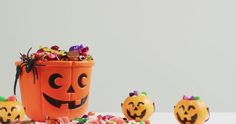 Colorful Halloween Pumpkin Buckets Filled with Candy - Download Free Stock Images Pikwizard.com