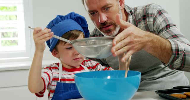 Middle-aged Man Teaching Young Boy to Bake in Home Kitchen - Download Free Stock Images Pikwizard.com