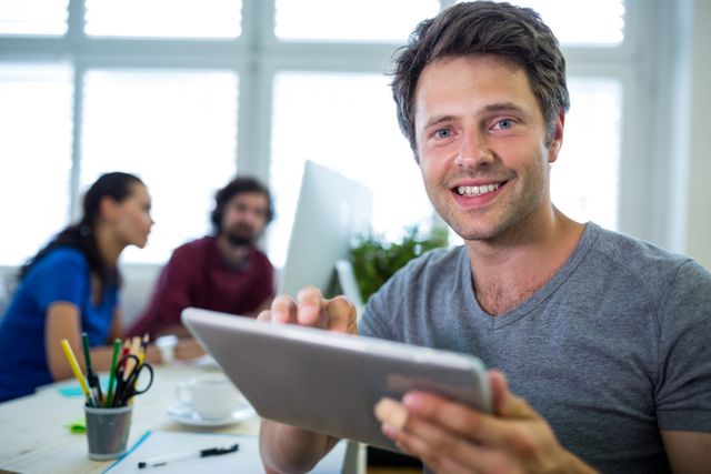 Portrait of smiling business executive using digital tablet in office 