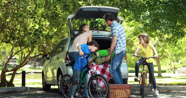 Family embarking on road trip adventure loading car with bicycles and picnic essentials - Download Free Stock Images Pikwizard.com