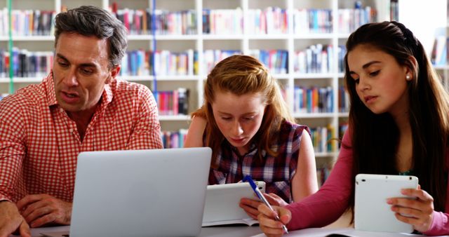 Teacher Assists Teen Students in Library STEM Lesson - Download Free Stock Images Pikwizard.com