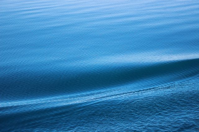 Photo depicts tranquil ocean waves gently rippling at sunrise. Ideal for websites and publications focusing on nature, marine life, relaxation, wellness, or travel. Can be used as a background image for calming presentations, promotional material, or as wall art to inspire a sense of peace and serenity.