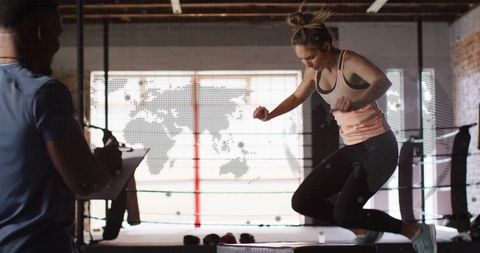 Athlete jumping on plyometric box in industrial gym