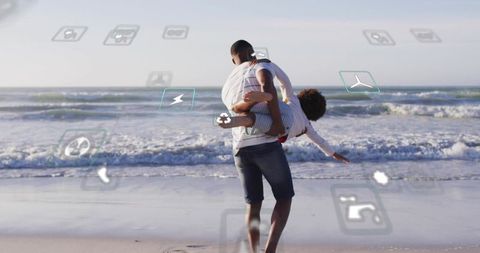 Father carrying child on shoreline with floating tech icons conveying connectivity and joy