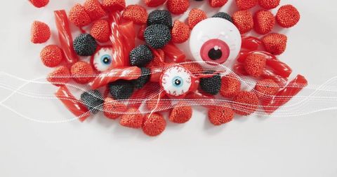 Top-down Halloween Candy Flatlay Featuring Eyeball Gummies, Red Licorice, Berry Jellies