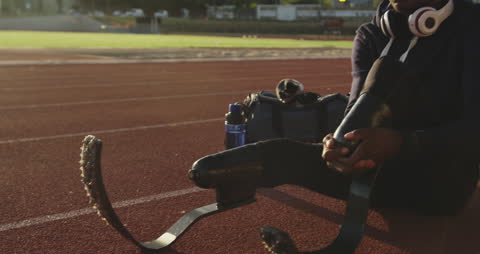 Athlete with Prosthetic Legs Preparing on Track