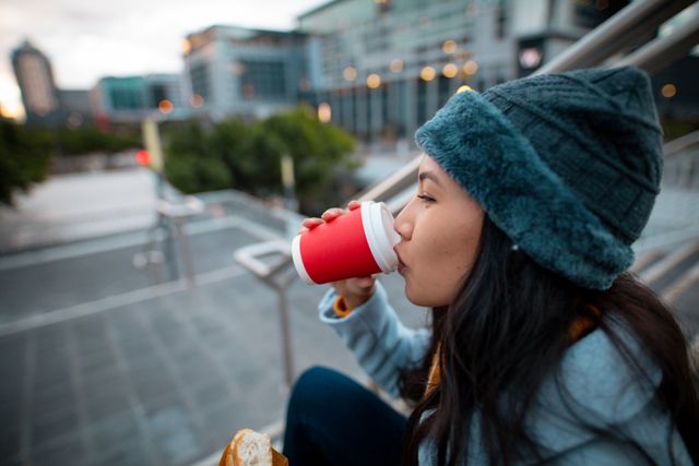 Profile of asian woman wearing hat, drinking coffe in street - Download Free Stock Photos Pikwizard.com