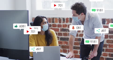 Colleagues Analyzing Social Media Metrics in Office with Face Masks