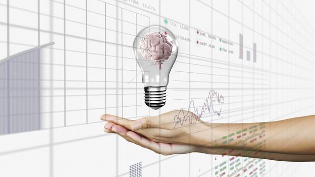 Digital concept representing technological and business innovation with a lightbulb containing a brain, hovering over a hand. Background includes translucent graphs and data points, highlighting themes of creativity and modern data processing. Useful for technology innovation, business data analysis, or scientific research themes in articles and multimedia content.