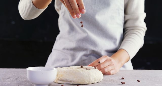 Person Adding Chocolate Chips to Dough in Kitchen - Download Free Stock Images Pikwizard.com