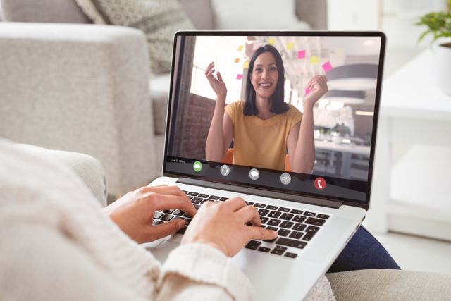 Caucasian businesswoman during video call with caucasian female colleague on laptop at home. unaltered, work from home, business, wireless technology, working, teamwork and office concept.