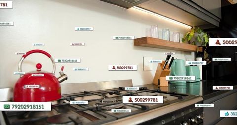 Sitting red whistling kettle on stainless stovetop with mint appliances and data tags