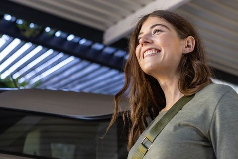 Smiling Woman in Parking Structure with Modern Urban Background