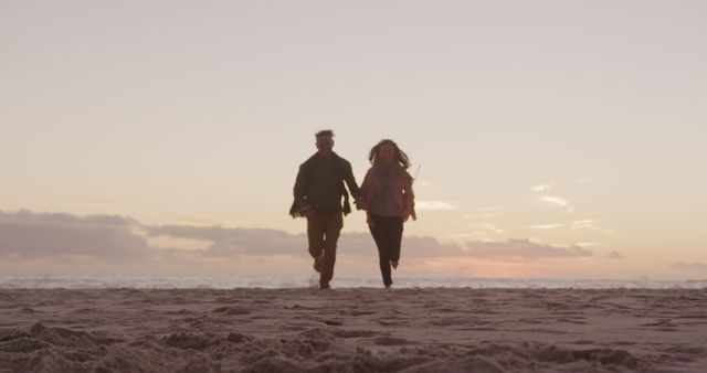Happy senior caucasian couple holding hands and running on beach at sunset, copy space. Freedom, relationship, retirement, romance, vacations, nature, wellbeing and active senior lifestyle, unaltered.