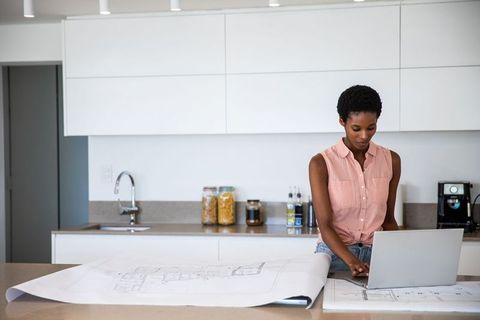 Architectural Designer Reviewing Floor Plans in Modern Kitchen