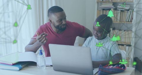 Father helping son with homework and digital learning tools