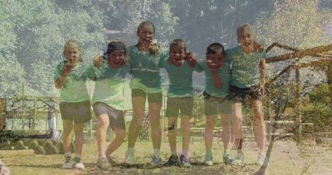 Group of kids linking arms smiling outdoors in park