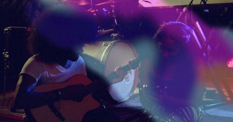 Musical duo performing in intimate concert setting at night