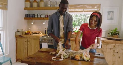 Couple unpacking fresh produce in rustic kitchen environment