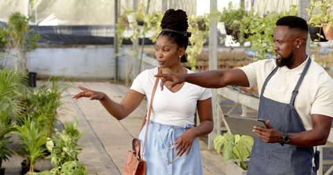African American Couple Exploring Plant Nursery with Tablet