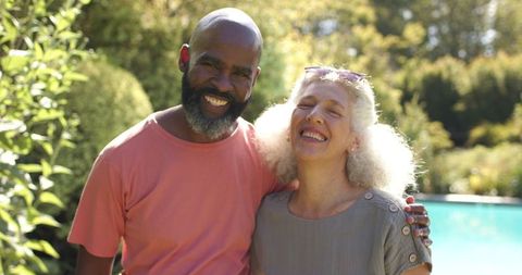 Senior Friends Embracing Joyfully in Sunlit Garden