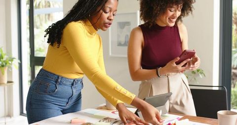 Collaborating on creative moodboard and product planning in bright modern workspace