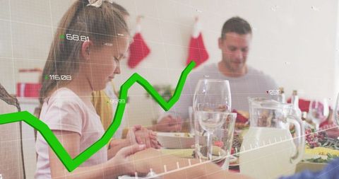 Young girl praying at holiday table with family and green rising graph overlay