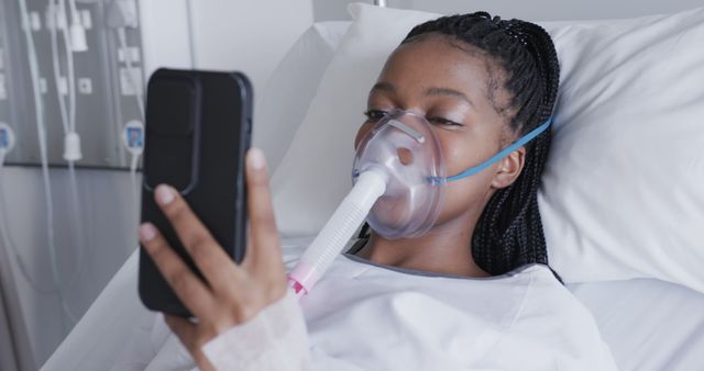 Young African American Woman Using Phone in Hospital Bed with Oxygen Mask - Download Free Stock Images Pikwizard.com