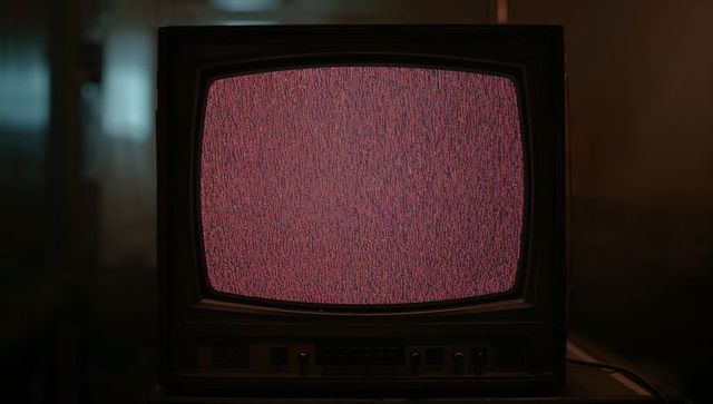 Vintage CRT TV Displaying Static in Dimly Lit Basement