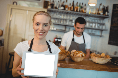 Transparent Tablet Held by Smiling Female Owner in Bakery Cafe