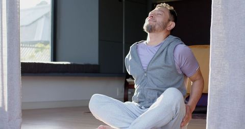 Senior Man Practicing Mindful Stretching at Home for Relaxation